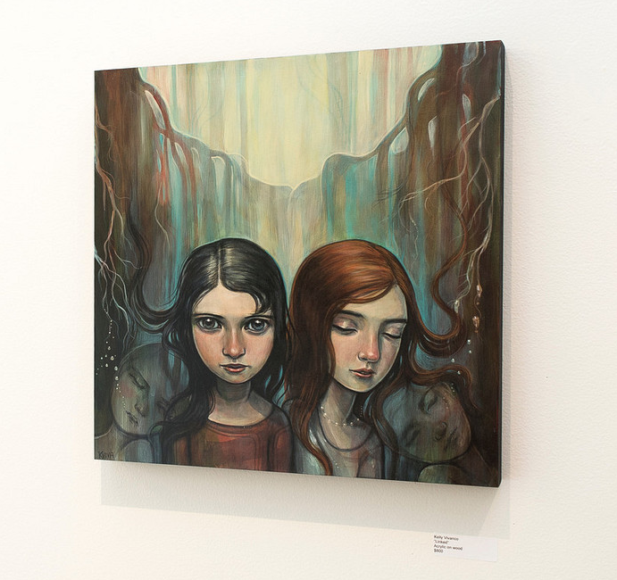 An acrylic on wood painting by Kelly Vivanco shows two girls with dark and red hair amid ethereal, flowing lines in muted tones, evoking a dreamlike forest. Displayed at Spoke Art Gallery.