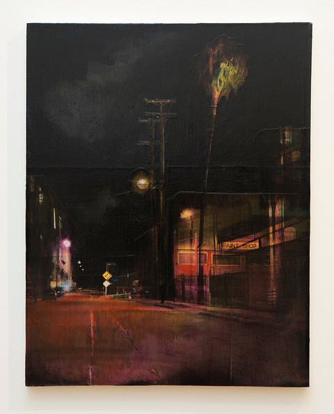 A Liz Brizzi painting portrays a nighttime urban street with dim lights and a lone palm tree. Flanked by buildings, the empty street features a faint halo in the sky. The artwork blends photo collage techniques and acrylics to create an eerie yet tranquil atmosphere.