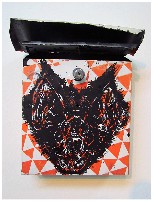 Euths wall-mounted enamel on metal mailbox, titled Untitled (bat), showcases a bold black bat with intricate details on its open lid. The background features an eye-catching geometric pattern of orange and white triangles.