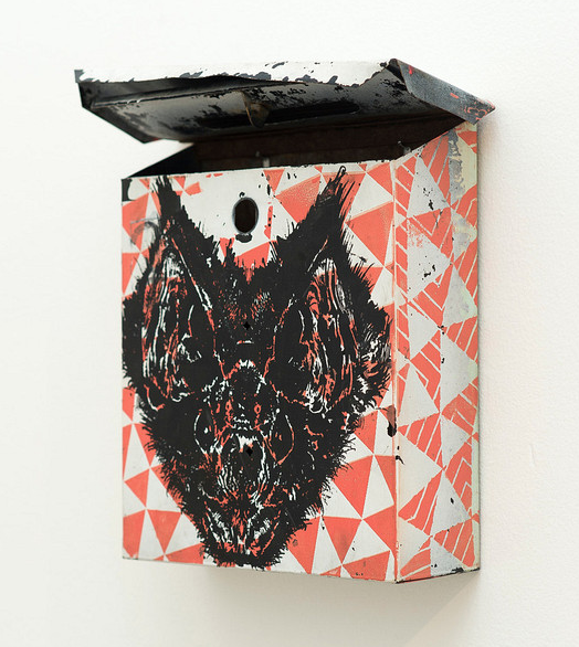 The Euth vintage mailbox features a stencil bat design inspired by Untitled (bat) against a red and white geometric pattern. Its enamel on metal construction shines with the lid open, mounted elegantly on the wall.