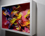 A 3D abstract art piece by Crystal Wagner, reminiscent of Terrarium IV, is displayed in a white shadow box frame. It features swirling cut paper layers in vibrant pinks, yellows, blues, and oranges against a bright pink backdrop.