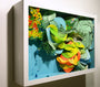 Crystal Wagners Terrarium VI features a vibrant, abstract 3D paper art in a shadow box frame. The cut paper creates intricate, swirling shapes in green, yellow, orange, and blue hues against a light blue background.