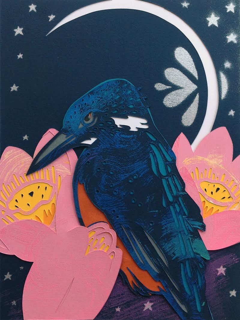 An illustrated Blue Banded Kingfisher with dark blue and orange feathers perches among pink flowers. A crescent moon and stars illuminate the night scene, enhanced by the artworks layered, cut-paper style by Kevin J Stanton.