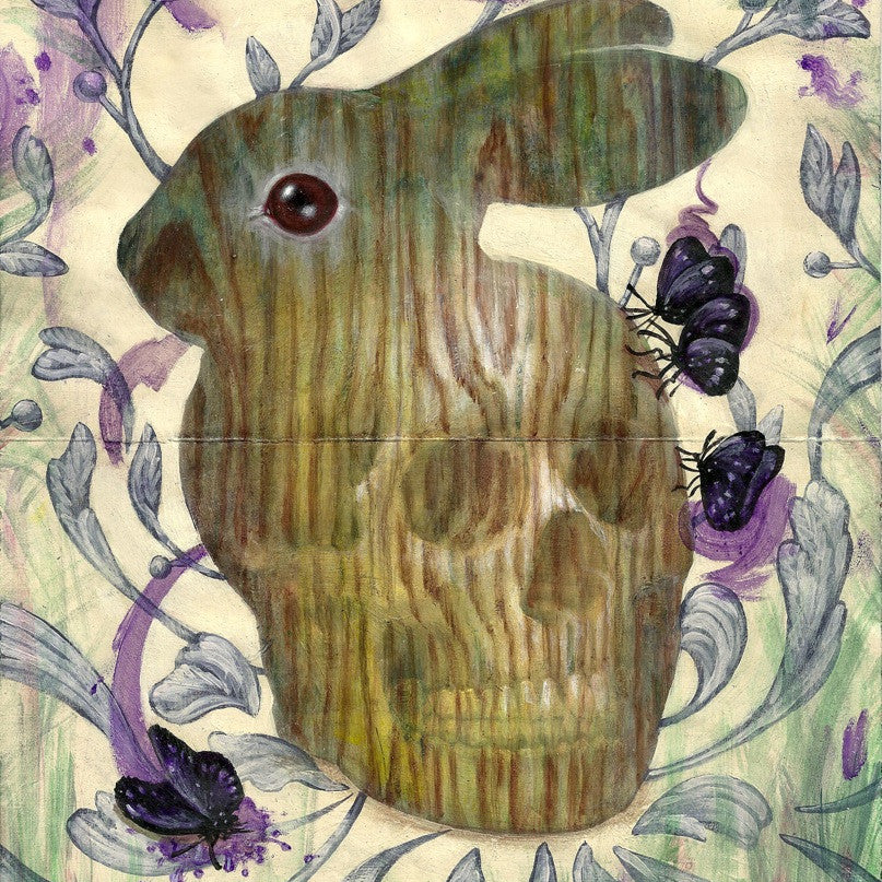 A wooden rabbit sculpture featuring a subtle skull pattern is surrounded by purple flowers and butterflies. Green and purple floral swirls fill the background, capturing Xiau-Fong Wees vibrant style, while acrylic on Moleskine techniques enhance the lively scene.