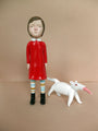 Doubleparlours hand-sculpted resin artwork showcases a person with a calm expression in a red dress and striped socks, accompanied by a small white creature with an orange snout. Set against a neutral background and accented with acrylic paint, this masterpiece captures the viewers imagination.